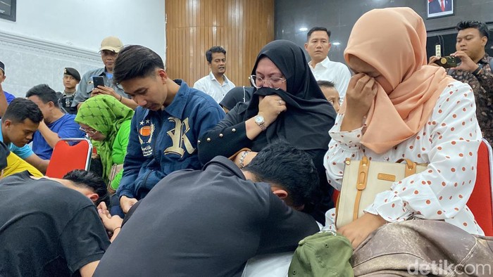 Orang tua siswa menangis bersama anaknya di Mapolresta Sukabumi.