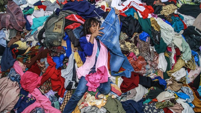 Seorang anak pengungsi korban banjir bandang memilih baju bekas layak pakai di SMK Negeri 4 Kota Ternate, Maluku Utara, Minggu (1/9/2024). Bantuan baju layak pakai hasil sumbangan dari donatur se-Maluku Utara tersebut untuk membantu para pengungsi yang terdampak banjir bandang guna mendapatkan baju layak pakai yang diperlukan sehari-hari.ANTARA FOTO/Andri Saputra/wpa.
