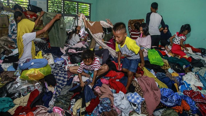 Seorang anak pengungsi korban banjir bandang memilih baju bekas layak pakai di SMK Negeri 4 Kota Ternate, Maluku Utara, Minggu (1/9/2024). Bantuan baju layak pakai hasil sumbangan dari donatur se-Maluku Utara tersebut untuk membantu para pengungsi yang terdampak banjir bandang guna mendapatkan baju layak pakai yang diperlukan sehari-hari.ANTARA FOTO/Andri Saputra/wpa.