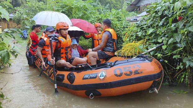 Personel Penjaga Pantai Filipina menggunakan perahu karet saat mengevakuasi warga yang terjebak banjir yang dipicu badai tropis Yagi (Philippine Coast Guard via AP)