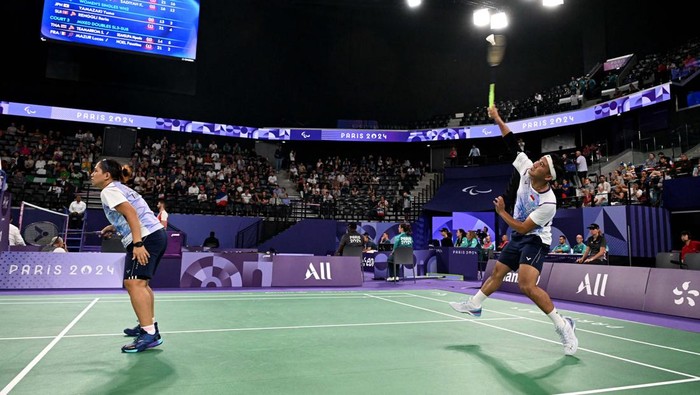 Paris 2024 Paralympics - Badminton - Mixed Doubles SL3-SU5 - Medal Ceremony - Porte de La Chapelle Arena, Paris, France - September 2, 2024
Gold medallists Ramdani Hikmat and Leani Ratri of Indonesia salute as they sing the national anthem on the podium. REUTERS/Jennifer Lorenzini