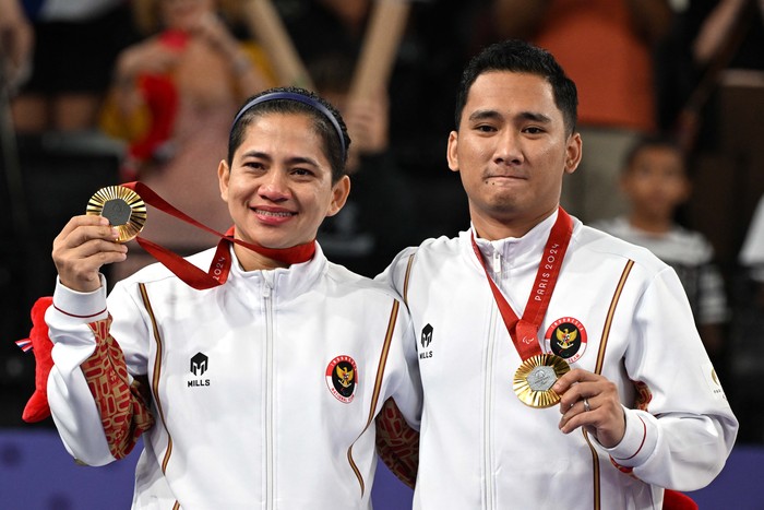 Paris 2024 Paralympics - Badminton - Mixed Doubles SL3-SU5 - Medal Ceremony - Porte de La Chapelle Arena, Paris, France - September 2, 2024
Gold medallists Ramdani Hikmat and Leani Ratri of Indonesia salute as they sing the national anthem on the podium. REUTERS/Jennifer Lorenzini