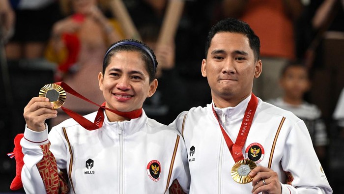 Ramdani/Leani Sumbang Emas Pertama RI di Paralimpiade 2024 Paris 2024 Paralympics - Badminton - Mixed Doubles SL3-SU5 - Medal Ceremony - Porte de La Chapelle Arena, Paris, France - September 2, 2024
Gold medallists Ramdani Hikmat and Leani Ratri of Indonesia salute as they sing the national anthem on the podium. REUTERS/Jennifer Lorenzini