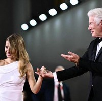 Richard Gere tak sendiri saat hadir di pemutaran perdana film Wolf’s di Festival Film Internasional Venice ke-81, Venesia, Italia, Minggu (1/9/2024). Dia membawa istri tercintanya, Alejandra Silva. Foto: Marco BERTORELLO / AFP