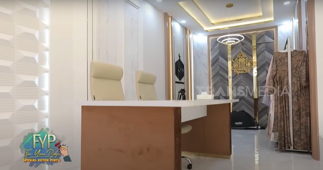 Kemudian pada sudut ruangan lantai bawah tanpa sekat yang menyambung ke ruang tamu juga terdapat area kerja Oki Setiana Dewi. Koleksi busana Oki Setiana Dewi juga di letakkan di sudut agar memudahkannya saat berjualan online di media sosial. Foto: dok. YouTube Trans7