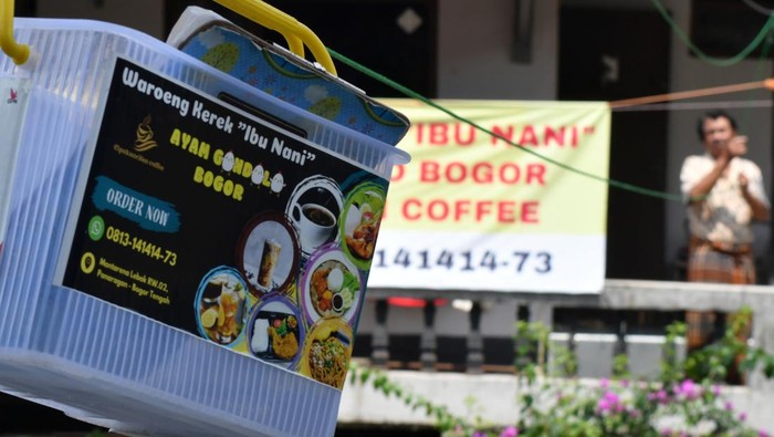 Warga membeli makanan dalam boks yang dipesan melalui tali kerekan melewati sungai Cipakancilan, Kampung Mantarena, Kelurahan Panaragan, Kota Bogor, Jawa Barat, Senin (2/9/2024). Warung makan kerekan di Kampung Mantarena merupakan program penataan kawasan kumuh yang dilakukan Dinas Perumahan dan Permukiman Kota Bogor tersebut bertujuan untuk membereskan persoalan kotornya sungai sekaligus membangkitkan perekonomian masyarakat. ANTARA FOTO/Arif Firmansyah/Spt.
