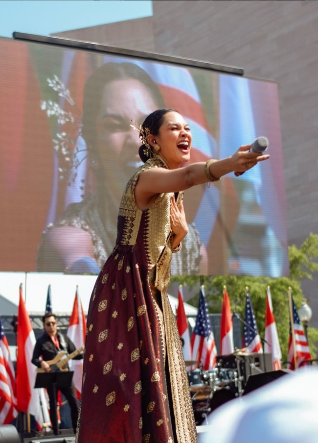 Wastra Indonesia ini tampil lebih modern dan universal berkat rancangan yang simple, siluet A-line dan detail leher tinggi. Foto: Instagram/@andienaisyah