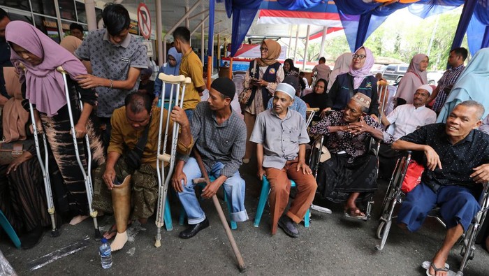 Seorang penyandang disabilitas mencoba berjalan seusai pemasangan kaki palsu di PT Angkasa Pura II, Kabupaten Aceh Besar, Aceh, Selasa (3/9/2024). PT Angkasa Pura II Bandara Internasional Blang Bintang bersama pemerintah Aceh dan Kick Andy Foundation melalui program kemerdekaan tanpa batas membangun inklusifitas dan kesetaraan di daerah itu dengan memberikan bantuan sebanyak 49 kaki palsu kepada penyandang disabilitas di lima kabupaten Provinsi Aceh. ANTARA FOTO/Ampelsa/Spt.
