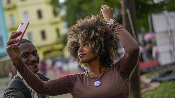 A woman with sunflowers in her hair waits to walk the runway at a fashion show of Afro hairstyles in Havana, Cuba, Saturday, Aug. 31, 2024. (AP Photo/Ramon Espinosa)