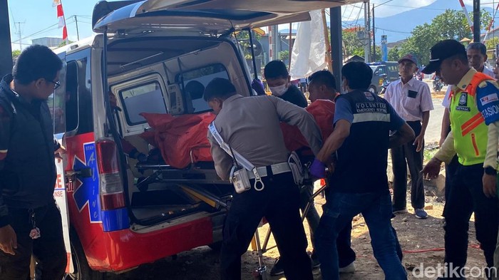 Petugas gabungan evakuasi jasad korban tertemper KA di Perlintsan KA Cimekar ke ambulans.