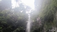 Suasana Curug Lawe, dengan wisatawan yang bersantai di bebatuan.