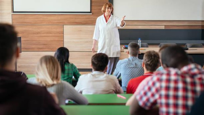 University students listening to the lectures in the lecture hall, enjoying the classes and teamwork. Group of young people are soon to be mathematics experts.