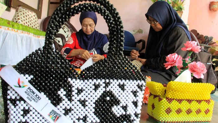 Perajin menyelesaikan pembuatan kotak tisu bertema PON XXI Aceh-Sumut di rumah Handycarf, Medan, Sumatera Utara, Rabu (4/9/2024). Menurut perajin, berbagai kerajinan berbahan akrilik seperti kotak tisu, vas bunga, dan kotak permen tersebut dijual seharga Rp15 ribu hngga Rp450 ribu tergantung bahan dan model. ANTARA FOTO/Yudi Manar/tom.
