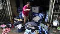 Warga membersihkan rumah dan barang-barang usai banjir mereda. AP/Aaron Favila