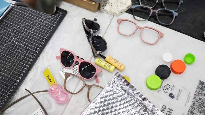 Debbie Wu tests her pair of sunglasses made from plastic waste at Trash Kitchen in Taipei, Taiwan August 19, 2024. REUTERS/Ann Wang