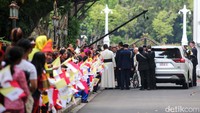 Paus Fransiskus, yang memakai kursi roda, terlihat bersalaman dengan anak-anak yang menunggunya. Paus terlihat menyapa mereka dan tersenyum.  