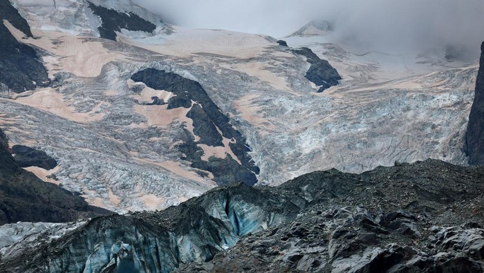Glaciologist at ETH Zurich and Head of the Glacier Monitoring in Switzerland (GLAMOS) Matthias Huss stands with a TV crew on the Morteratsch Glacier amid climate change, in Pontresina, Switzerland, September 3, 2024. REUTERS/Denis Balibouse