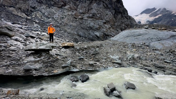 Penampakan Gletser di Swiss yang Terus Menyusut Glaciologist at ETH Zurich and Head of the Glacier Monitoring in Switzerland (GLAMOS) Matthias Huss stands with a TV crew on the Morteratsch Glacier amid climate change, in Pontresina, Switzerland, September 3, 2024. REUTERS/Denis Balibouse