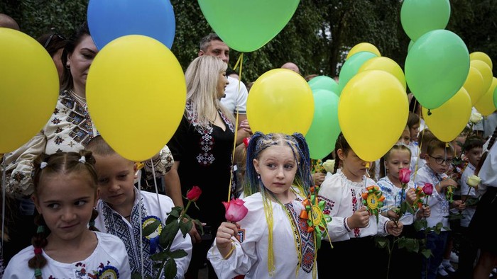 Potret Anak-anak Ukraina Kembali Sekolah di Tengah Serangan Rusia First-grades hold balloons during the traditional ceremony for the first day of school in Zaporizhzhia, Ukraine, Sunday Sept. 1, 2024. Zaporizhzhia schoolchildren celebrated the traditional first day of school near the frontline. With the front just 40 kilometers away, the war is never far from the minds of teachers and families. (AP Photo/Evgeniy Maloletka)