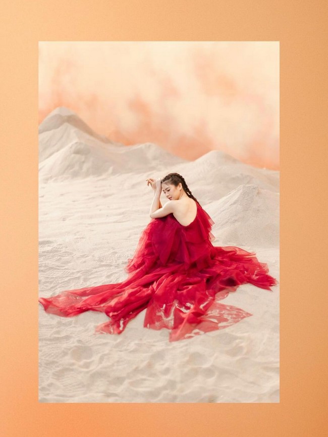 Dengan warna gaun merah menyala dan latar krem yang kontras, wanita 28 tahun ini bak bunga merekah di tengah gurun pasir. Foto: Instagram/@clarissatanoe @solemnstudios