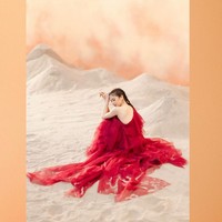 Dengan warna gaun merah menyala dan latar krem yang kontras, wanita 28 tahun ini bak bunga merekah di tengah gurun pasir. Foto: Instagram/@clarissatanoe @solemnstudios