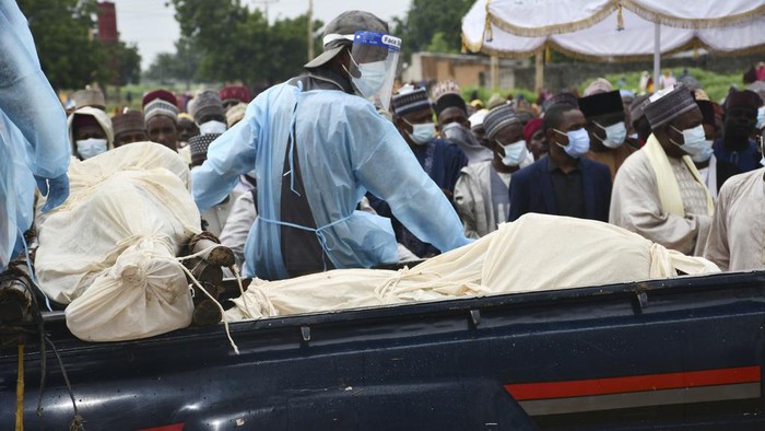 People pay respects as people killed by suspected Boko Haram Islamist extremists are transported for burial, in Tarmuwa, northeast Nigeria, Tuesday, Sept. 3, 2024. (AP Photo/Michael Abu)