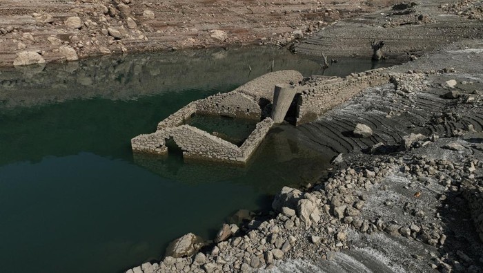 Desa Tenggelam di Yunani Muncul Kembali Akibat Kekeringan, Ini Potretnya The reappearing remains of buildings of the village of Kallio, which was intentionally flooded in 1980 to create a reservoir that would help meet the water needs of Greek capital Athens, are seen following receding water levels caused by drought, in Lake Mornos, Greece, September 3, 2024. REUTERS/Stelios Misinas