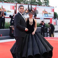 Pelantun lagu ‘Poker Face’ ini melengkapi busananya dengan  sepatu boots Giuseppe Zanotti dan headpiece bergaya gothic rancangan Philip Treacy, bernentuk seperti tanduk yang dihiasi renda di pinggirannya. Foto: Getty Images