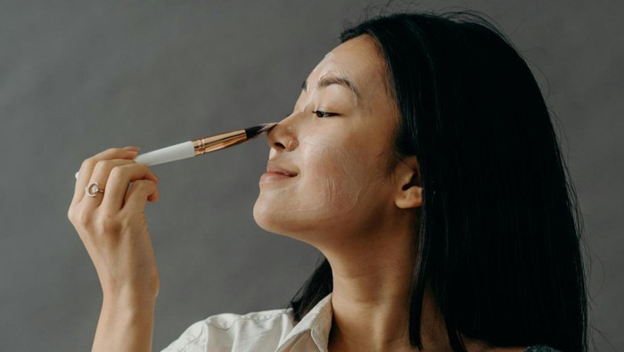 Ilustrasi wanita sedang memakai scrub untuk eksfoliasi