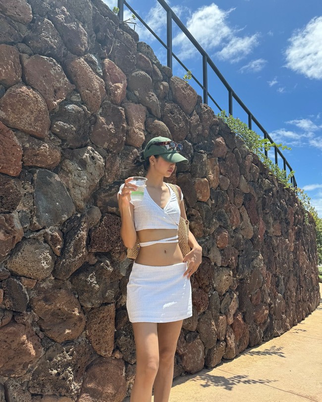 Penampilan Lisa BLACKPINK tak kalah elegan saat memakai satu set crop top putih dan towel skirt dari brand Amerika KITH. Penampilannya dilengkapi dengan kacamata hitam, baseball cap, dan tas Louis Vuitton ‘OnTheGo’ seharga $3,700 (Rp 59 juta). Foto: dok. Instagram @lalalalisa_m