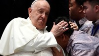 Para penerima manfaat itu memeluk Paus Fransiskus dan menangis terharu. (REUTERS/Guglielmo Mangiapane) 