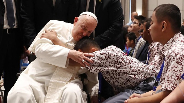 Momen Haru Penyandang Disabilitas Peluk Erat Paus Fransiskus Pope Francis blesses a beneficiary from a charitable organization at the Indonesian Bishops' Conference Headquarters in Jakarta, Indonesia, 05 September 2024. ADI WEDA/Pool via REUTERS