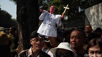 Ada juga warga yang membawa boneka Paus Fransiskus.  