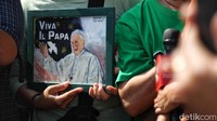 Selain kipas, ada juga warga yang membawa lukisan Paus Fransiskus.  
