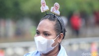 Para umat juga terlihat memakai aksesoris bergambarkan wajah Paus Fransiskus. 
