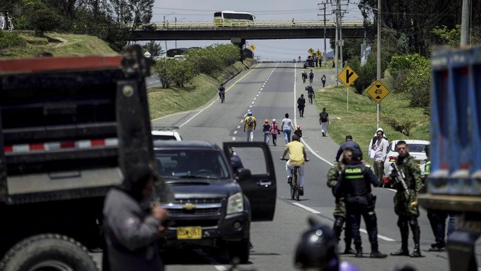 People walk along the Tocancipa-Gachancipa road due to lack of transport caused by truckers' protests, on the outskirts of Tocancipa, Colombia, Wednesday, Sept. 4, 2024. (AP Photo/Ivan Valencia)