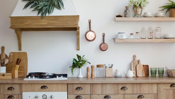 1296111659 Light wooden kitchen interior with kitchen utensils on the shelves and on the wall. Beautiful kitchen interior design