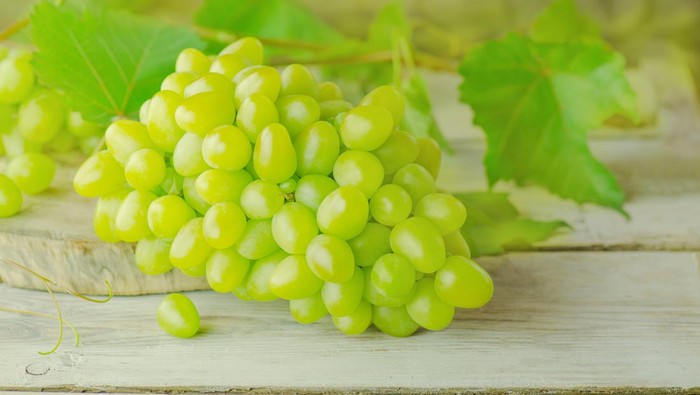 White wine grapes. Grapes on a wooden table.  Sweet green grape over the wooden background