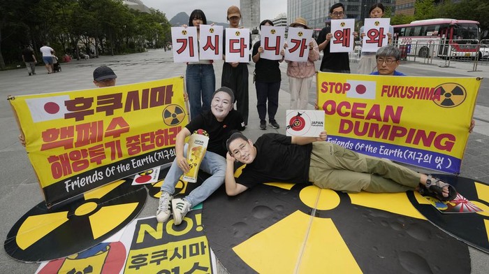 Aksi Protes Menentang PM Jepang Fumio Kishida Berkunjung ke Korsel South Korean environmental activists wearing masks of Japanese Prime Minister Fumio Kishida, bottom right, and South Korean President Yoon Suk Yeol perform during a rally against Kishida's planned visit in Seoul, South Korea, Thursday, Sept. 5, 2024. The banners, center back, read,