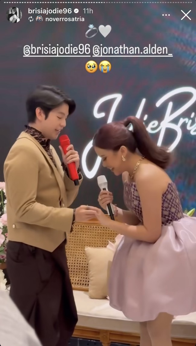 Setelah mengeluarkan cincin yang sudah disiapkannya, Alden pun melamar dan menyematkan cincin tersebut di jari manis Jodie. Momen tersebut diketahui bertepatan dengan perilisan lagu terbaru Jodie yang bertajuk Tak Ada Restu. Foto: Instagram/@brisiajodie96/@jonathan.alden_