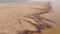 Tampak bagian sungai yang mengering dan hanya menyisakan pasir tanpa air cukup lebar.  