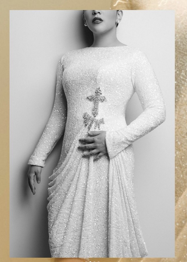 Kreasi tersebut berupa sequin column dress putih lengan panjang yang dihiasi detail berupa salib di bawah dada. Rok yang dibuat dengan aksen menjuntai memberikan kesan elegan dan feminin.  (Foto: Dok. Stella Rissa)