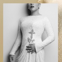 Kreasi tersebut berupa sequin column dress putih lengan panjang yang dihiasi detail berupa salib di bawah dada. Rok yang dibuat dengan aksen menjuntai memberikan kesan elegan dan feminin.  (Foto: Dok. Stella Rissa)