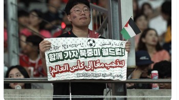 Seorang suporter Korsel memegang tulisan mari bersama-sama lolos Piala Dunia. Foto: X.com