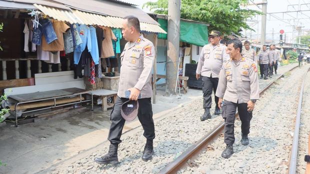 Polres Jakut membagikan makanan gratis kepada warga di pinggir rel KA.