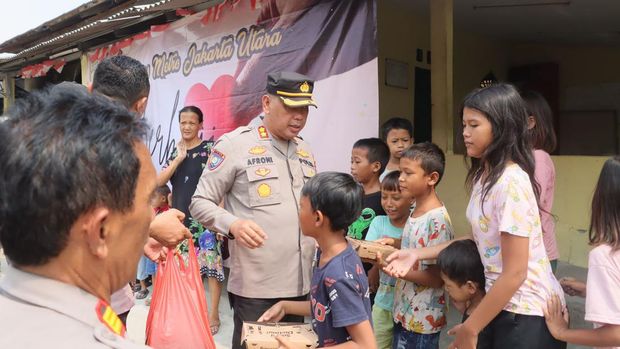 Polres Jakut membagikan makanan gratis kepada warga di pinggir rel KA.