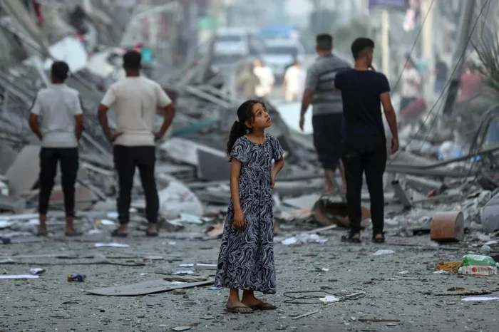 Seorang anak berusia 7 tahun bernama Amal, sedang di tengah lingkungannya di Gaza setelah rumah-rumah tetangganya rata dengan tanah.