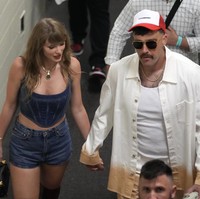 Sebelum pertandingan, Taylor dan Travis tampak jalan bersama menuju arena. Travis terlihat mengenakan kemeja ombre dan celana camel keluaran Lanvin. Foto: Dok. AP