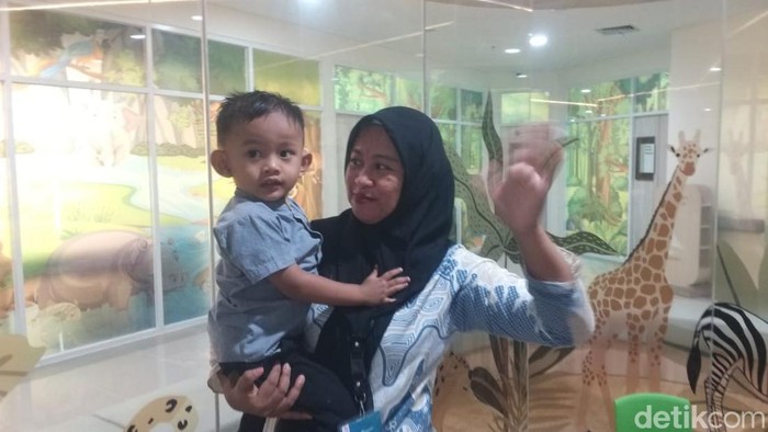 Warga asal Gorontalo, Yeyen S Huyo (33) dan anak bungsunya bernama Akbar (3) selesai menjalani operasi pemasangan implan di telinganya atas bantuan Presiden Jokowi.