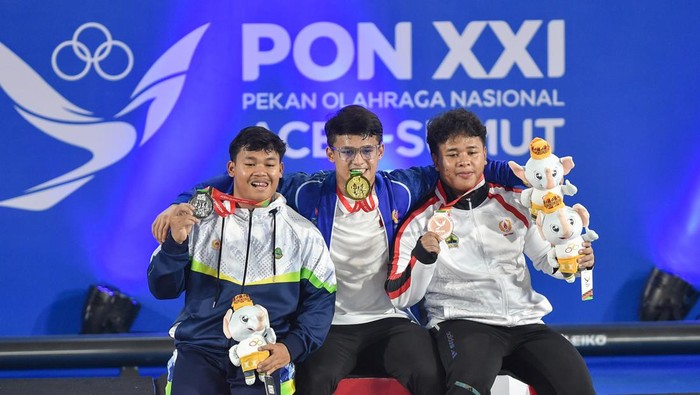 Lifter Banten Rizki Juniansyah melakukan angkatan clean and jerk saat angkat besi kelas 89 kilogram putra PON XXI Aceh-Sumut 2024 di GOR Seuramoe Angkat Besi Harapan Bangsa, Banda Aceh, Aceh, Sabtu (7/9/2024). Rizki Juniansyah berhasil meraih emas sekaligus memecahkan rekor nasional dengan total angkatan 360 kg melampaui rekor sebelumnya yakni 337 kilogram atas nama Muhammad Zul Ilmi. ANTARA FOTO/Budi Candra Setya/pras.